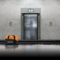 Quick Dam Flood Control duffle bag kit placed in front of an elevator during flooding, providing fast flood protection for commercial buildings.