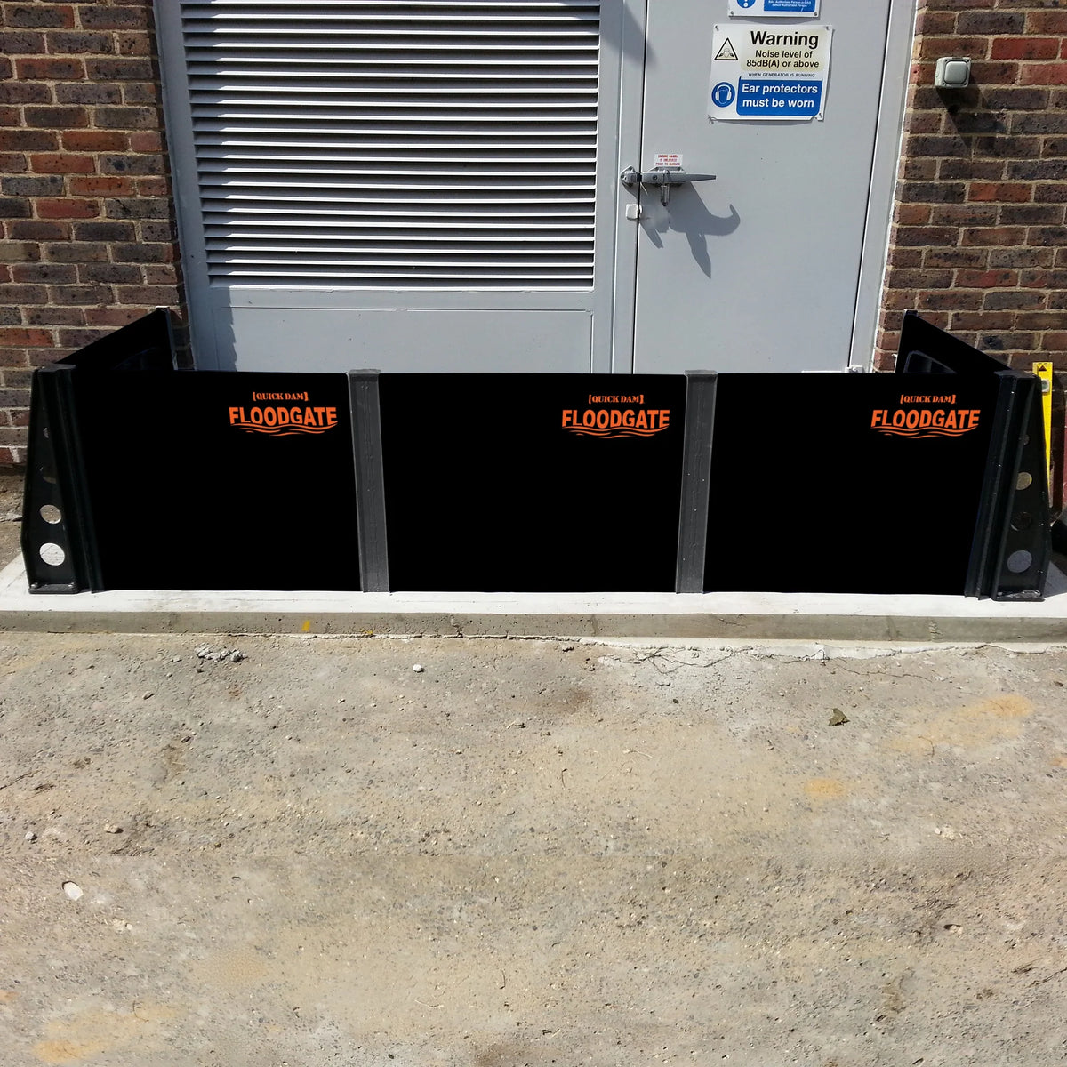 Quick Dam Flood Gates with stanchions installed at a commercial doorway providing heavy-duty flood protection and water barrier security.