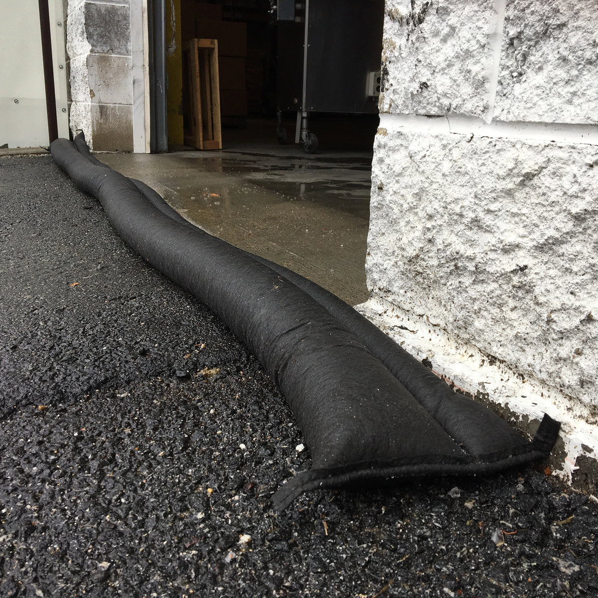 Quick Dam Flood Barrier placed across a garage doorway to block and divert floodwater from entering the building.