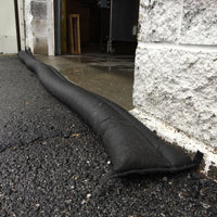 Quick Dam Flood Barrier placed across a garage doorway to block and divert floodwater from entering the building.