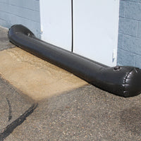 Quick Dam Water Curb filled and positioned at a commercial doorway, blocking flood water from entering the building.