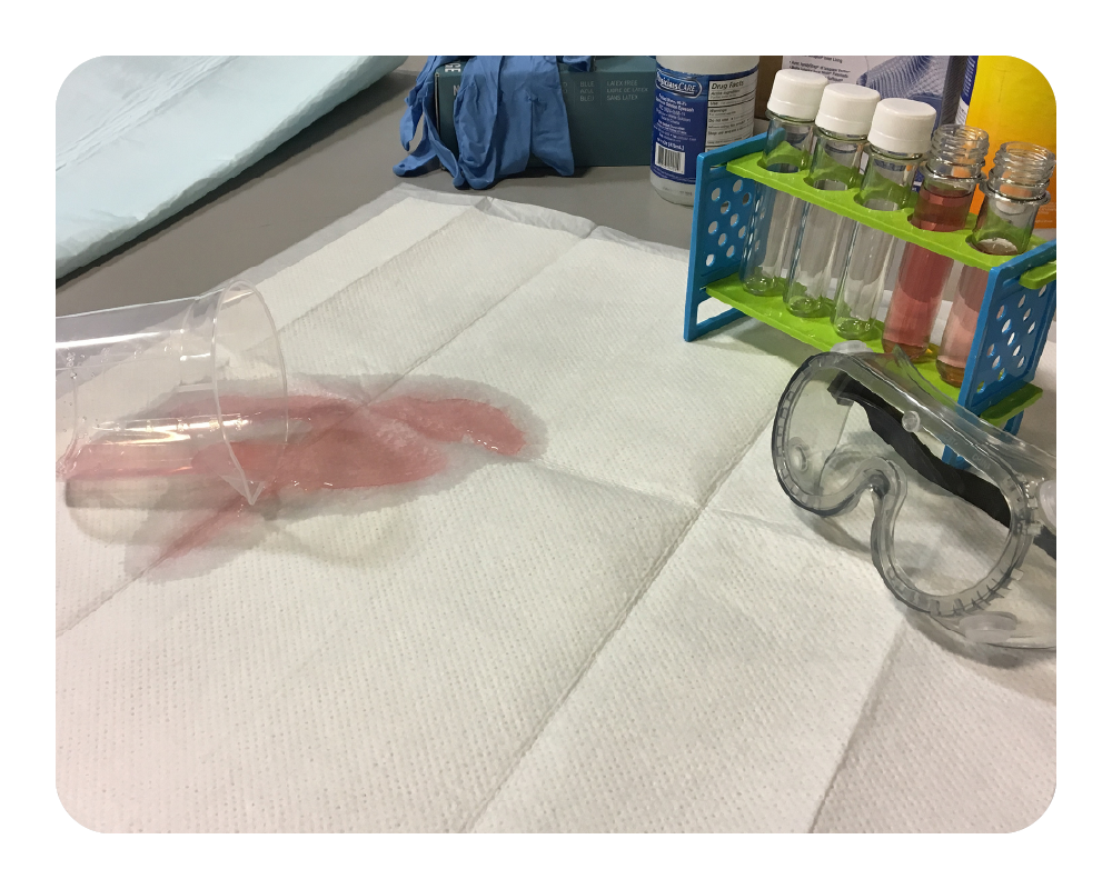 Lab setting with a white drip mat, gloves, and various lab equipment on a table. 