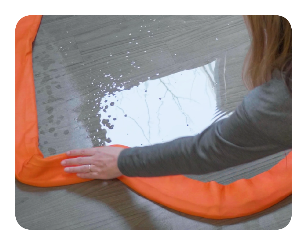 Person using a water dam to absorb and redirect water