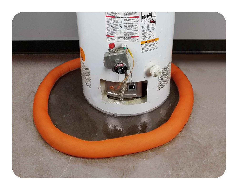White water heater with an orange water dam on a concrete floor.