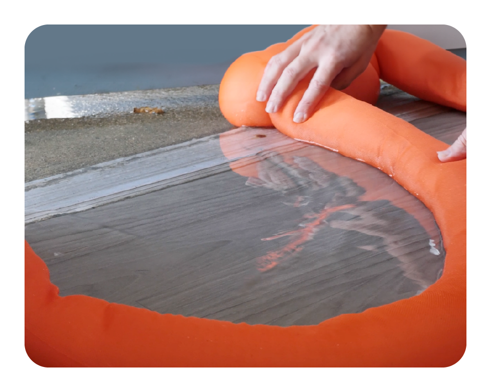 Person using a water dam to absorb and redirect water