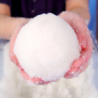 Hand holding a snowball with a blurred background