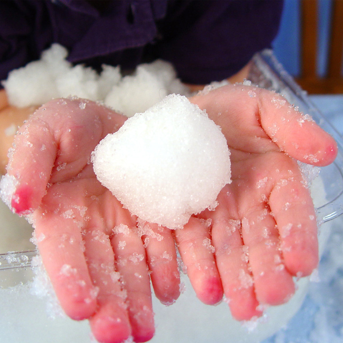 Child's hands holding a block of snow