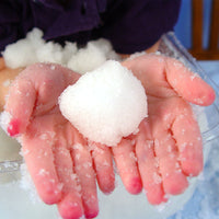 Child's hands holding a block of snow