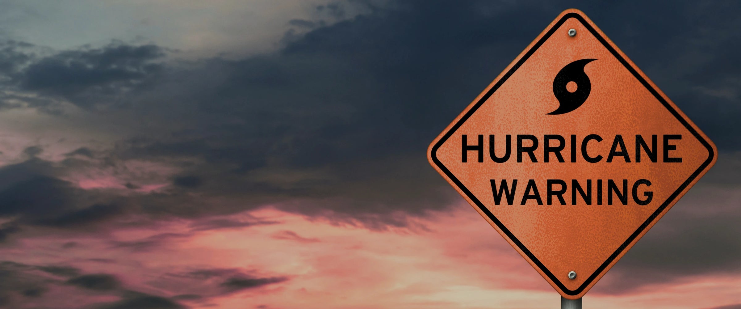 Hurricane warning sign with a dark, stormy sky in the background