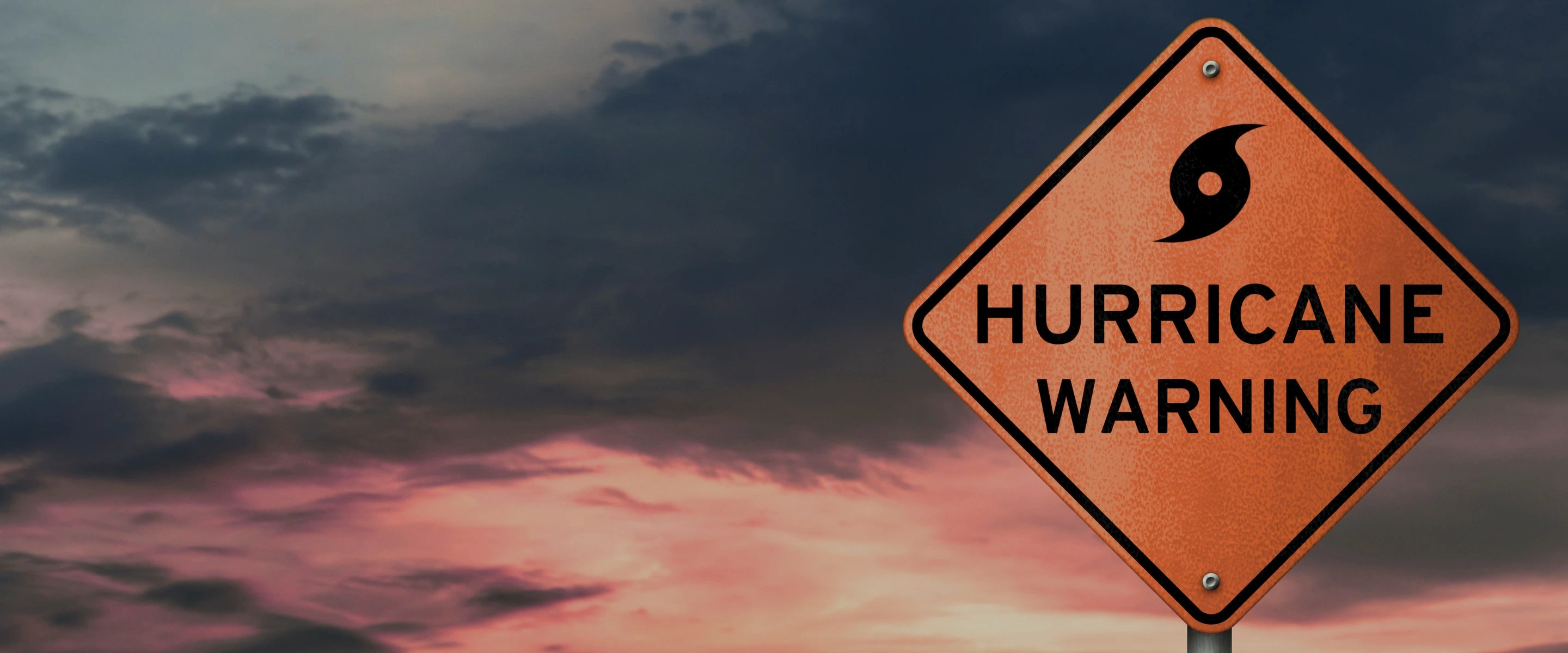 Hurricane warning sign with a dark, stormy sky in the background