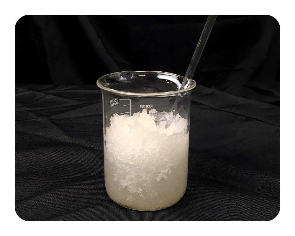 Beaker filled with a white liquid lock powder on a black background
