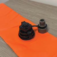 Log Dam COMING SOON hose adapter fitting on a bright orange material surface.