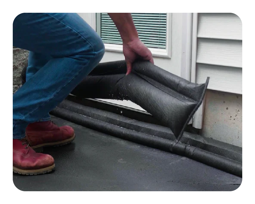 Person installing a black flood barrier outside of a door