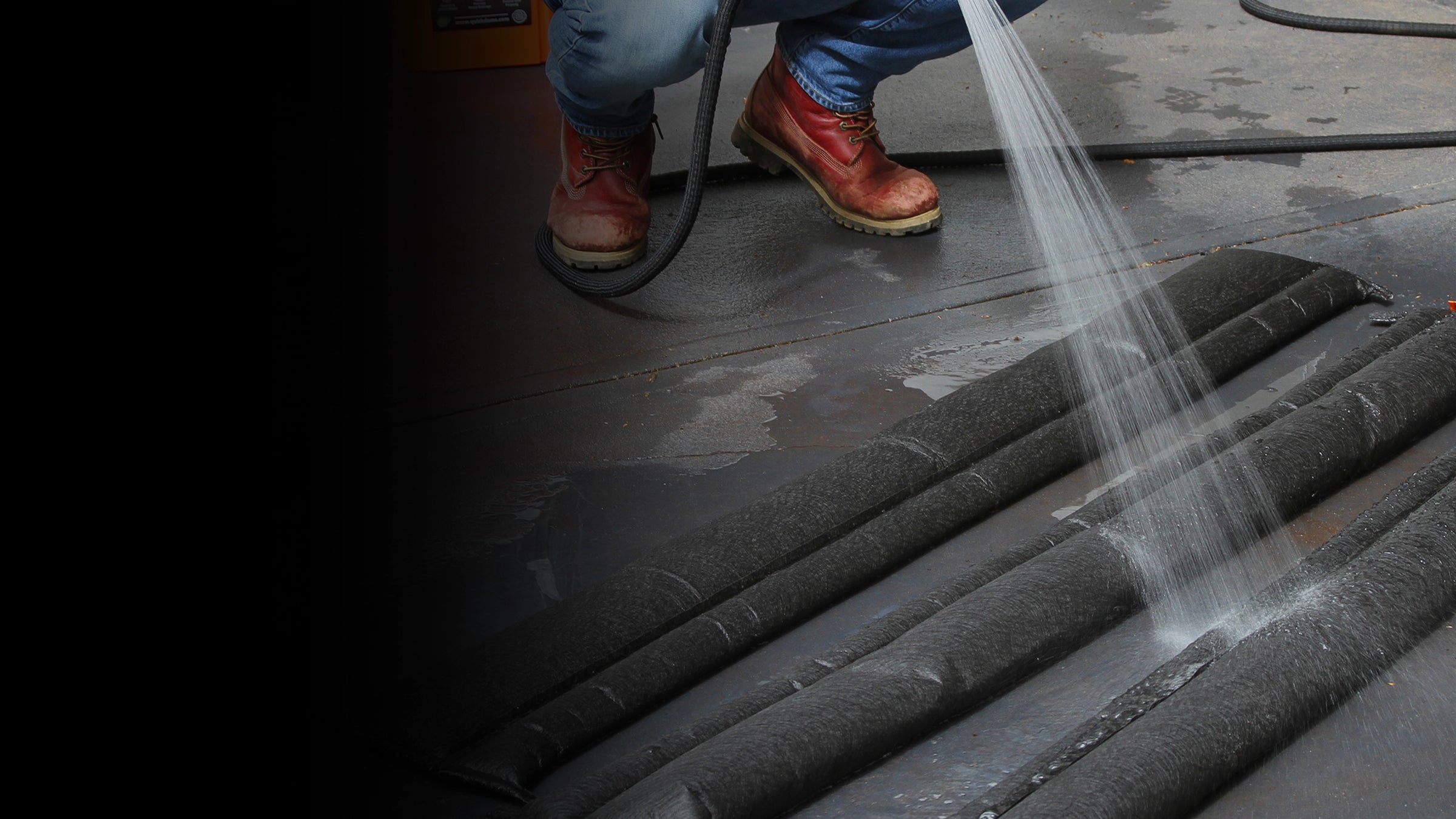 Person using a hose to activate flood barriers