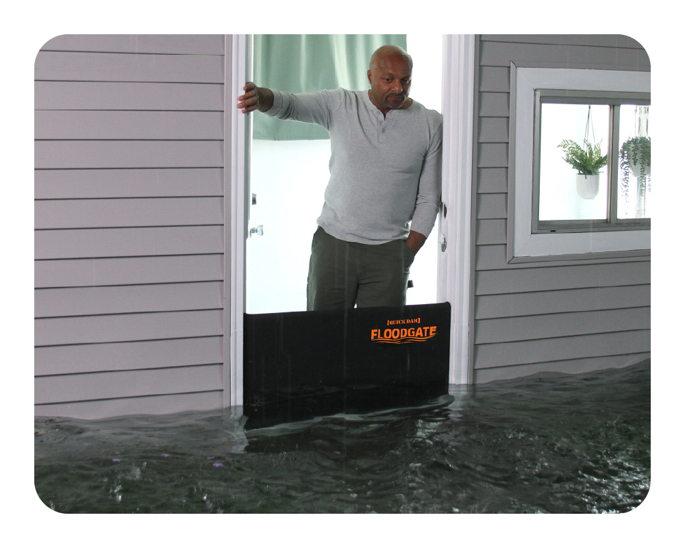 Person using a Floodgate to control water flow in a doorway during flooding
