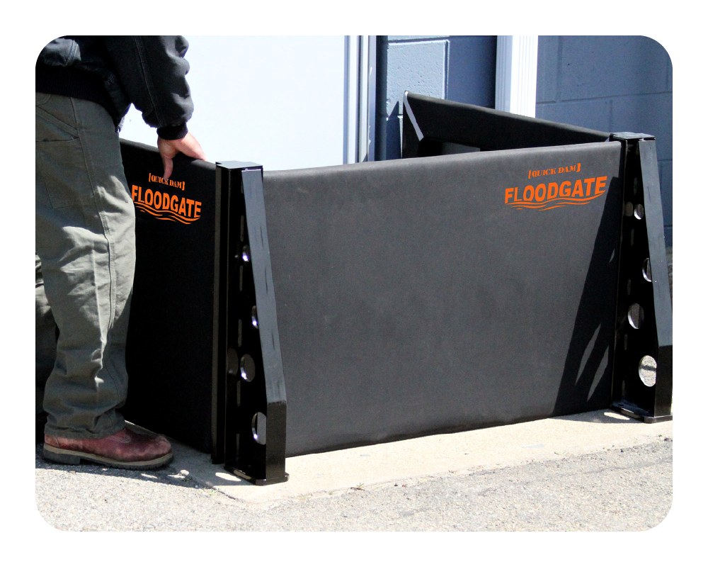 Person interacting with a large black Floodgate product on a sidewalk.
