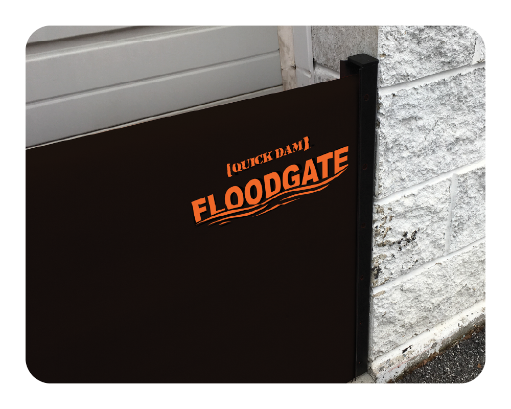 Black floodgate with 'Quick Dam Floodgate' text against a gray wall.