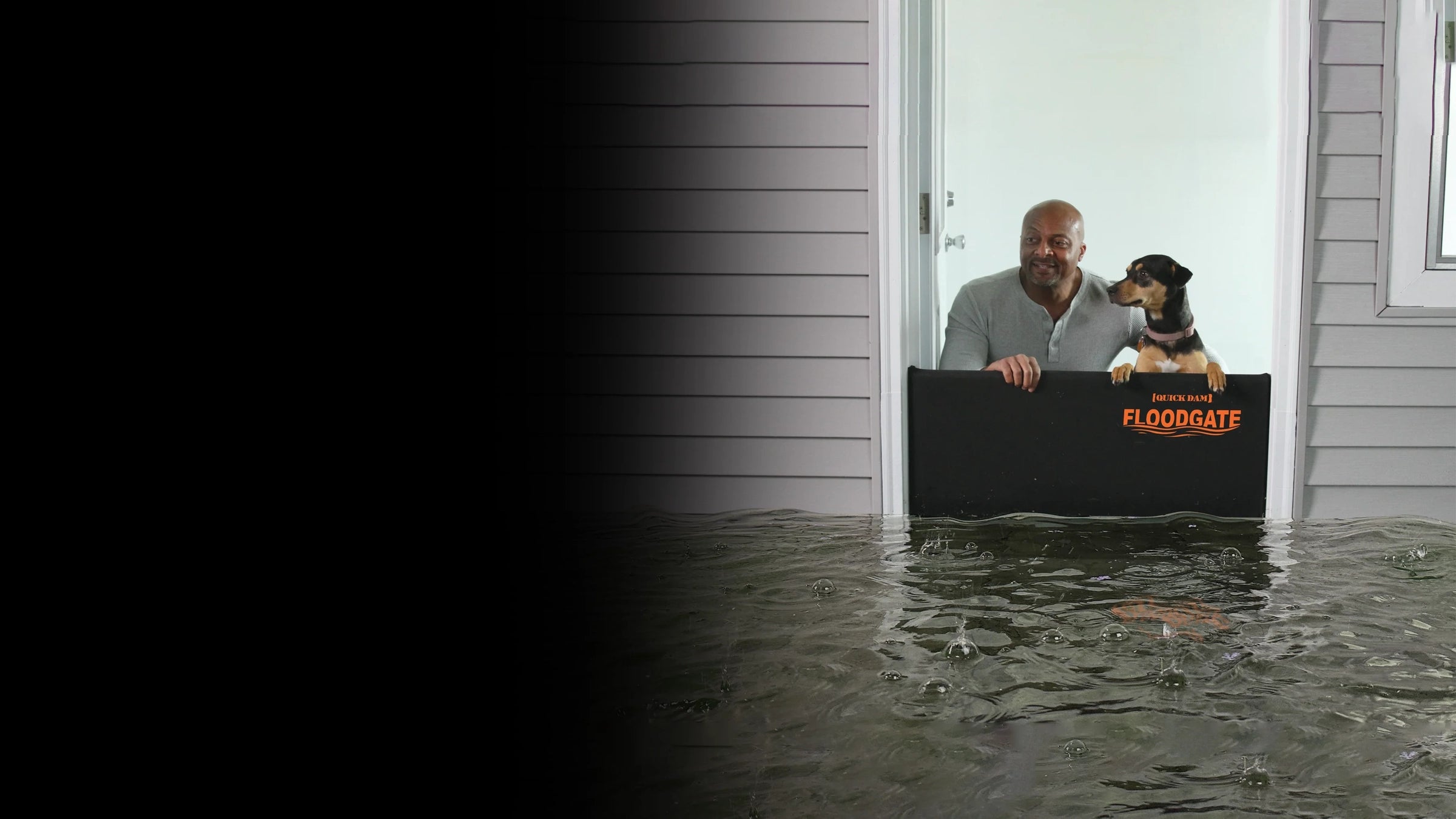 Man and dog using a Flood Gate during a flood