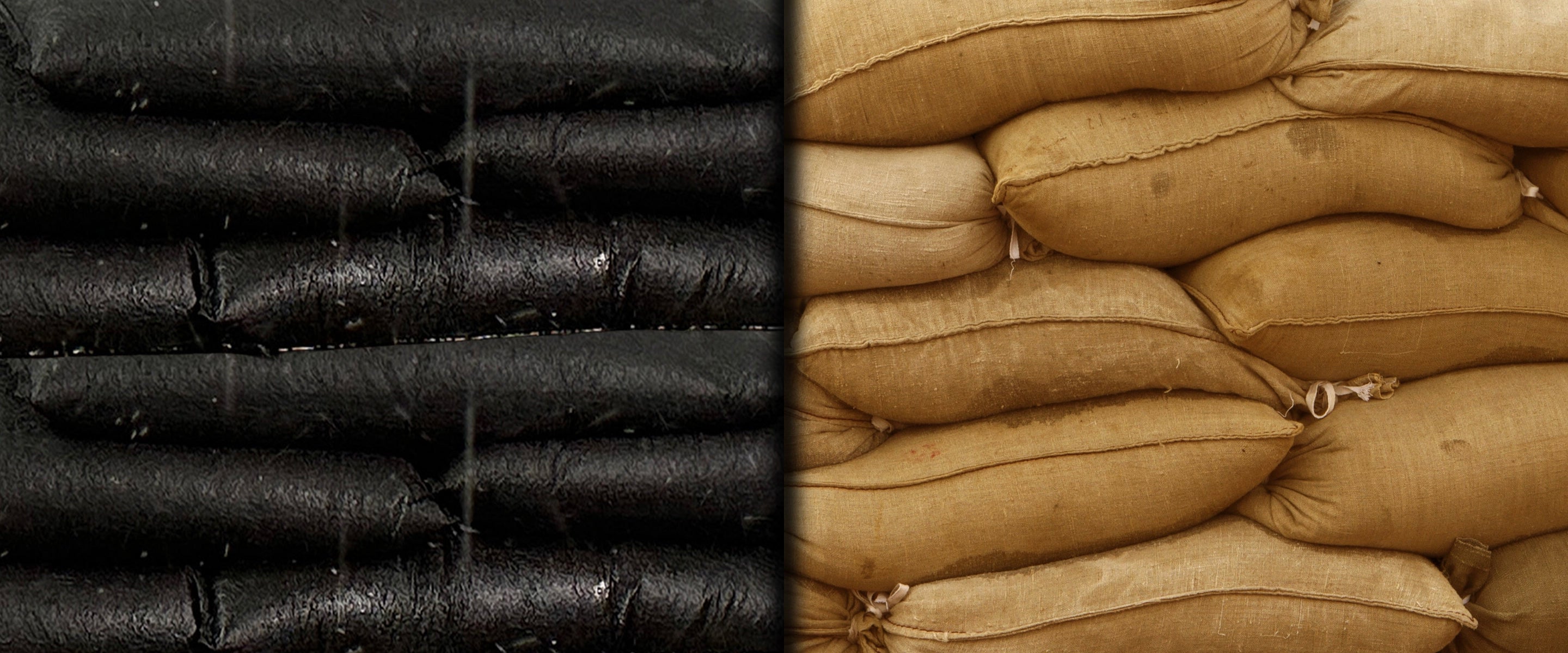 Close-up of black flood bags and brown sandbags.