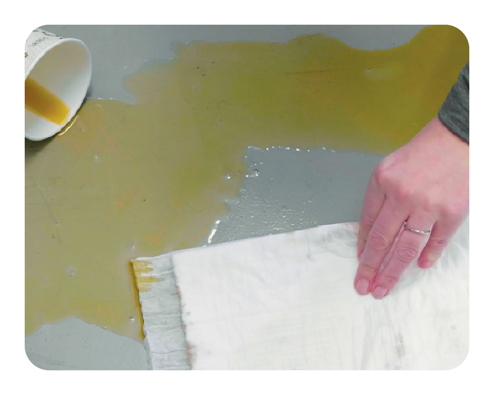 Person cleaning a coffee spill with a quick dam mat