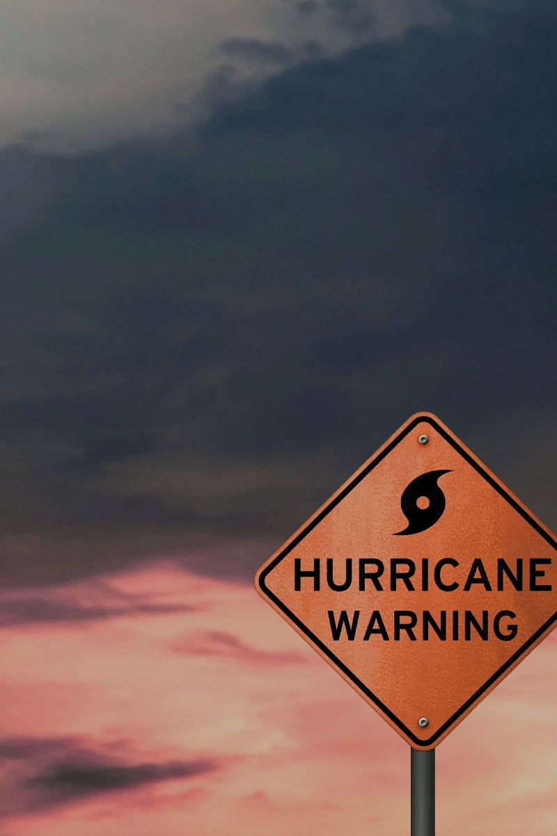 Hurricane warning sign with dark clouds and pinkish sky in the background
