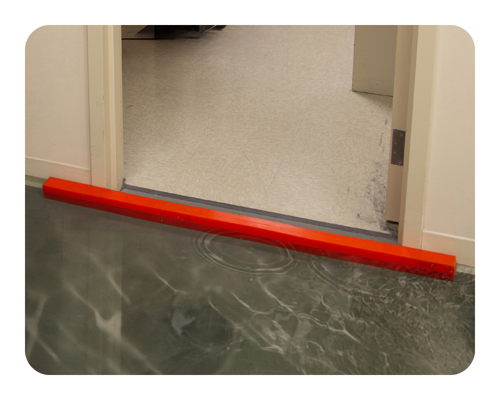 Orange Insta-Dam in a doorway holding back flood water