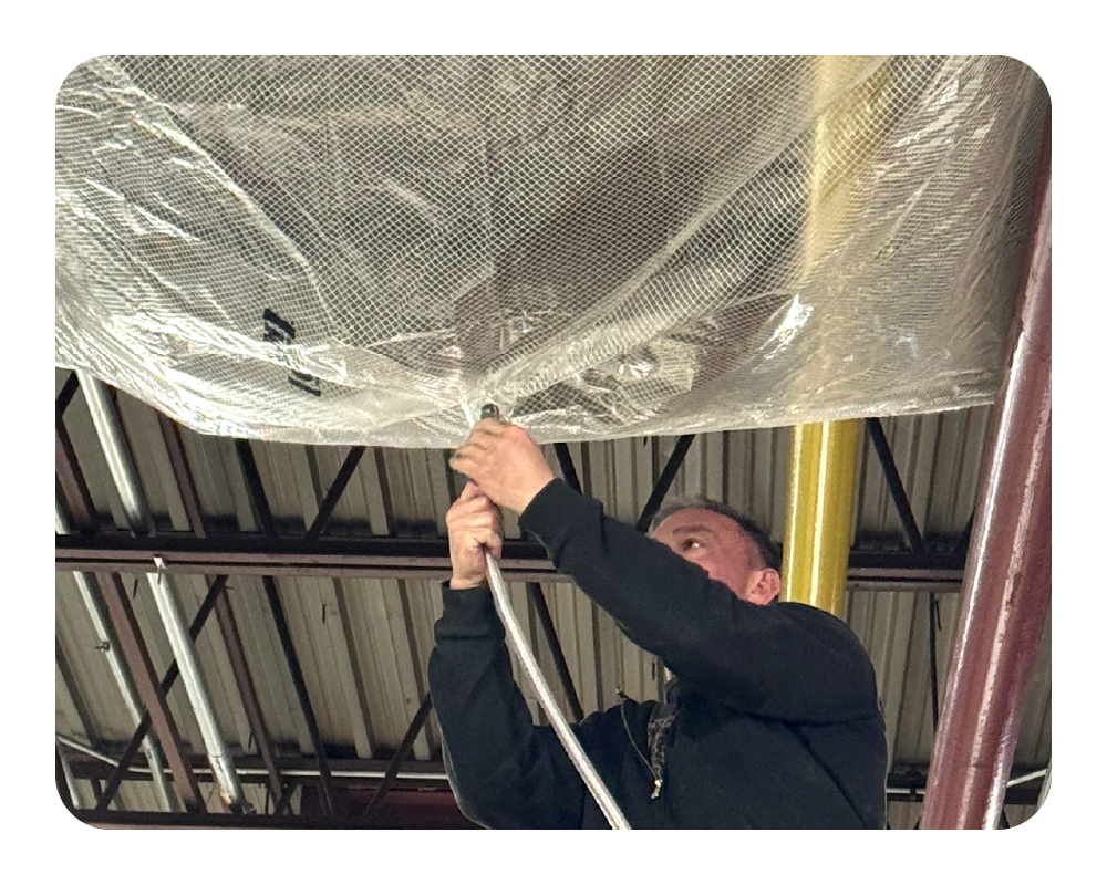 Person adjusting a hose to a leak diverter in an industrial setting