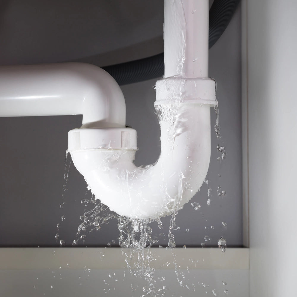 White pipe with water leakage against a gray background