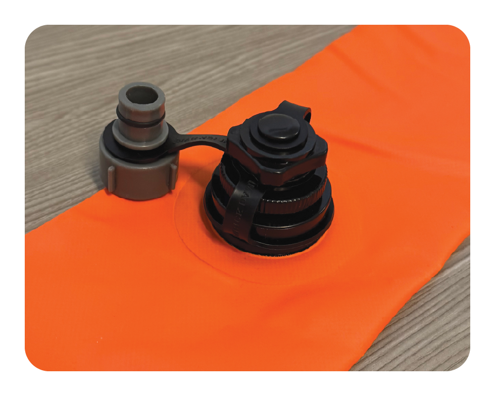 Black mechanical components on an orange log dam and gray background