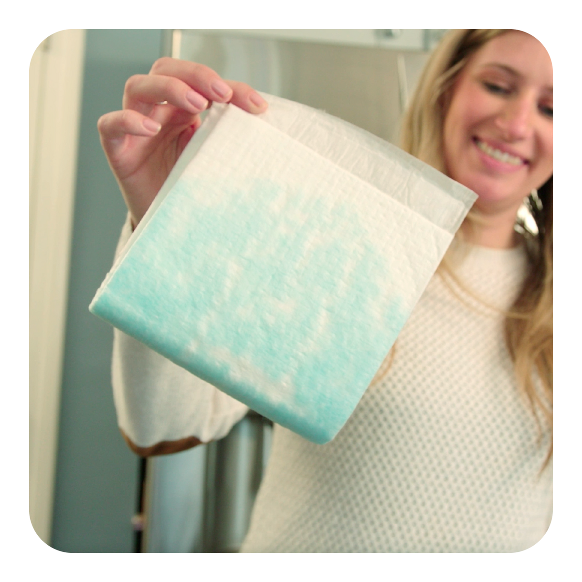 Person holding a light blue and white Quick Dam Mat