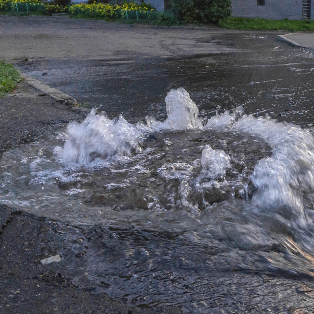Spilled water on a street surface with a curb in the background