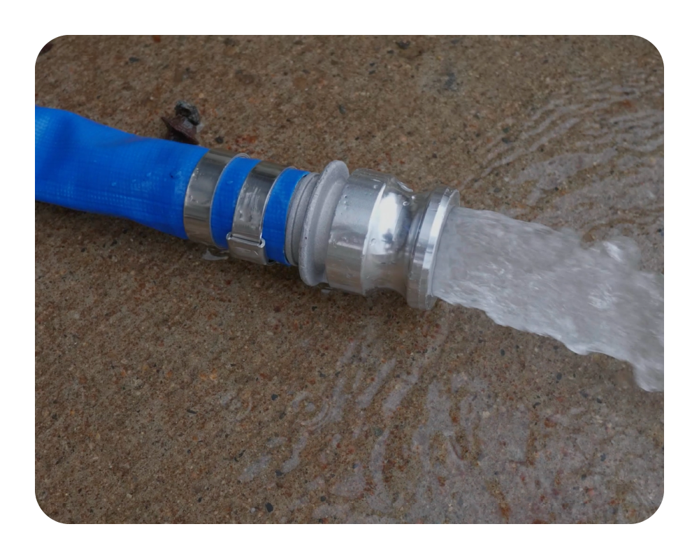 Quick Dam Pump Kit Hose spraying water on a concrete surface