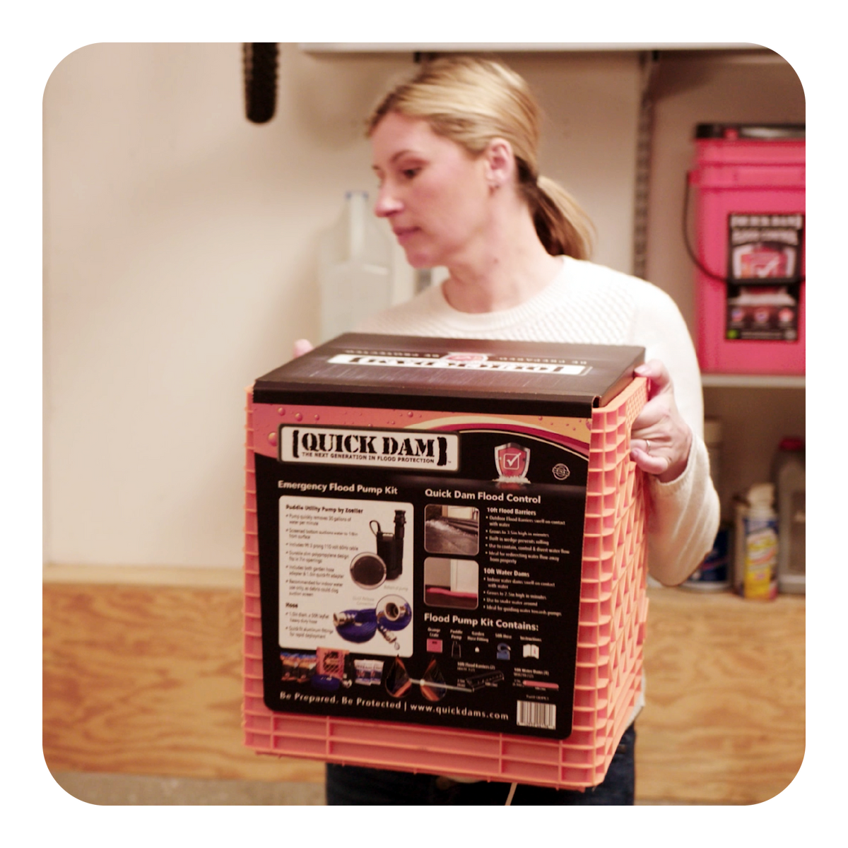 Person holding a orange and black Quick Dam emergency flood pump kit crate