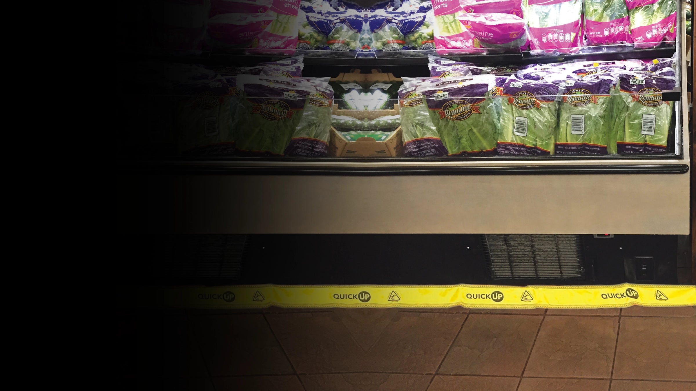 Grocery store shelf with food bags and a yellow quick up below to catch water and condensation