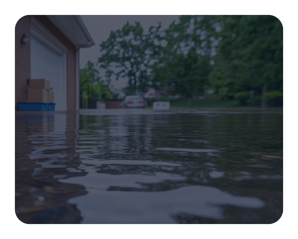 Flooded street with water reaching up to a house's garage door.