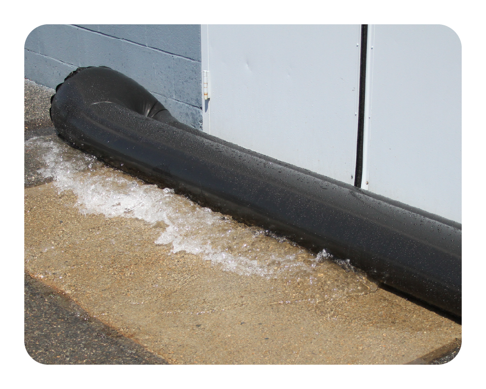 Black water curb on a concrete surface with a white door in the background