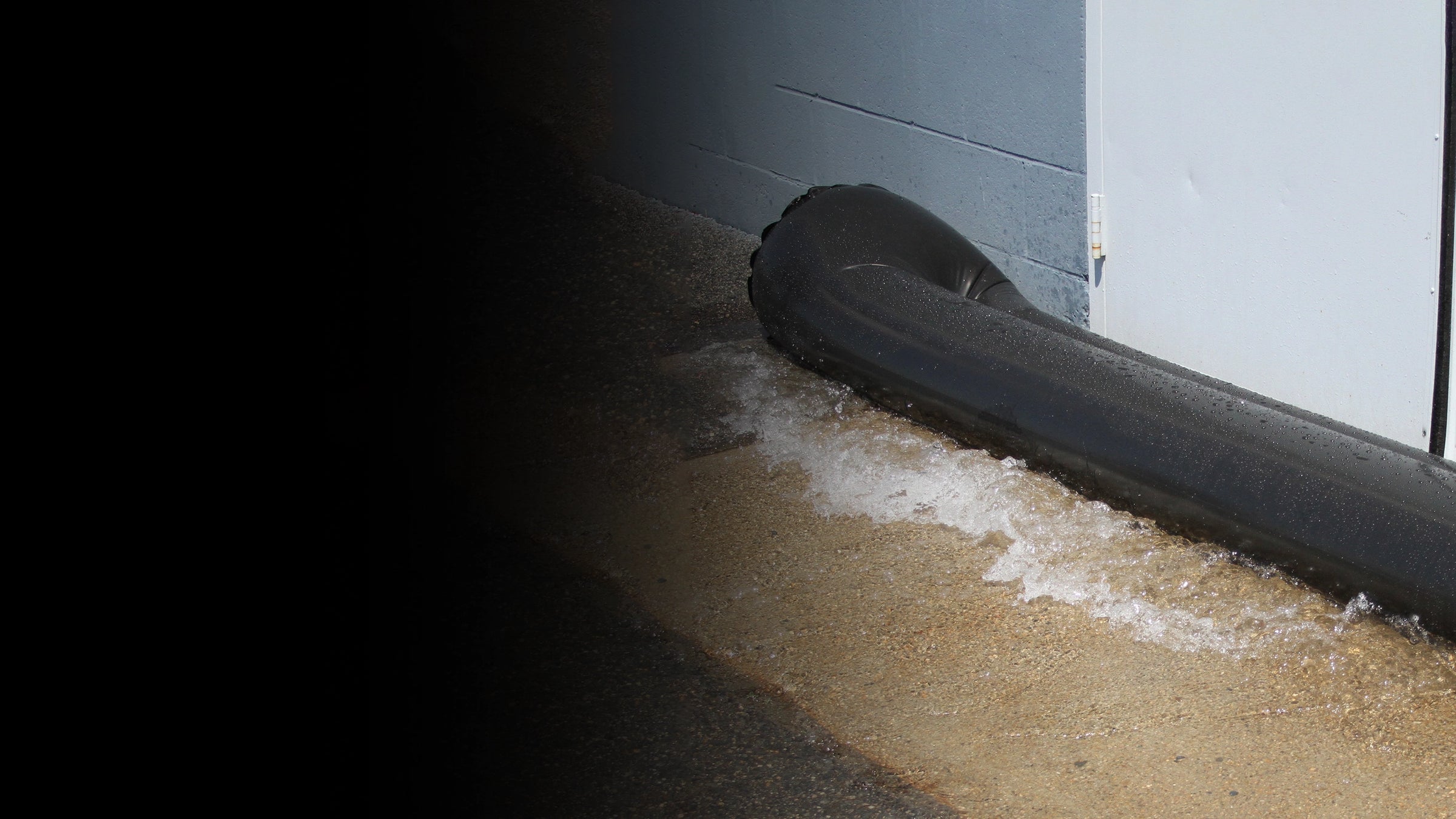 Black water curb holding back water in front of a doorway