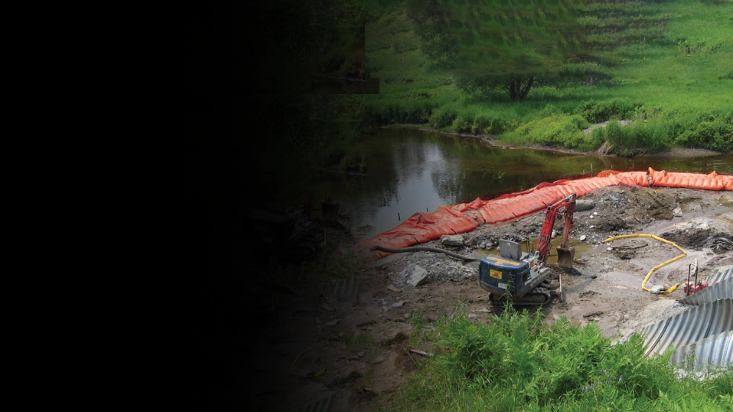Construction site by a river with greenery