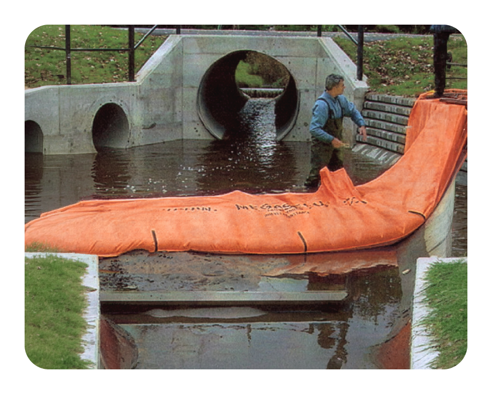 Person standing next to an orange water force in front of a concrete culvert.