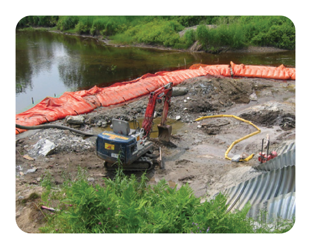 Excavator near a river with an orange water force creating a coffer dam