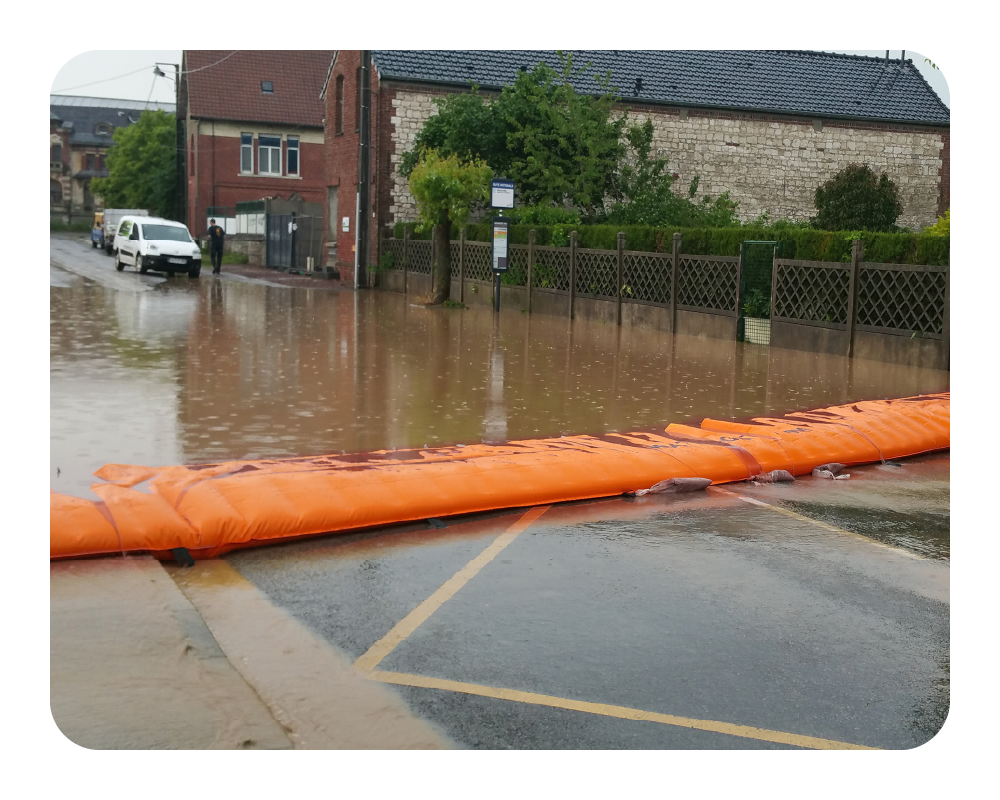 Flooded street with an orange water force in front of a building