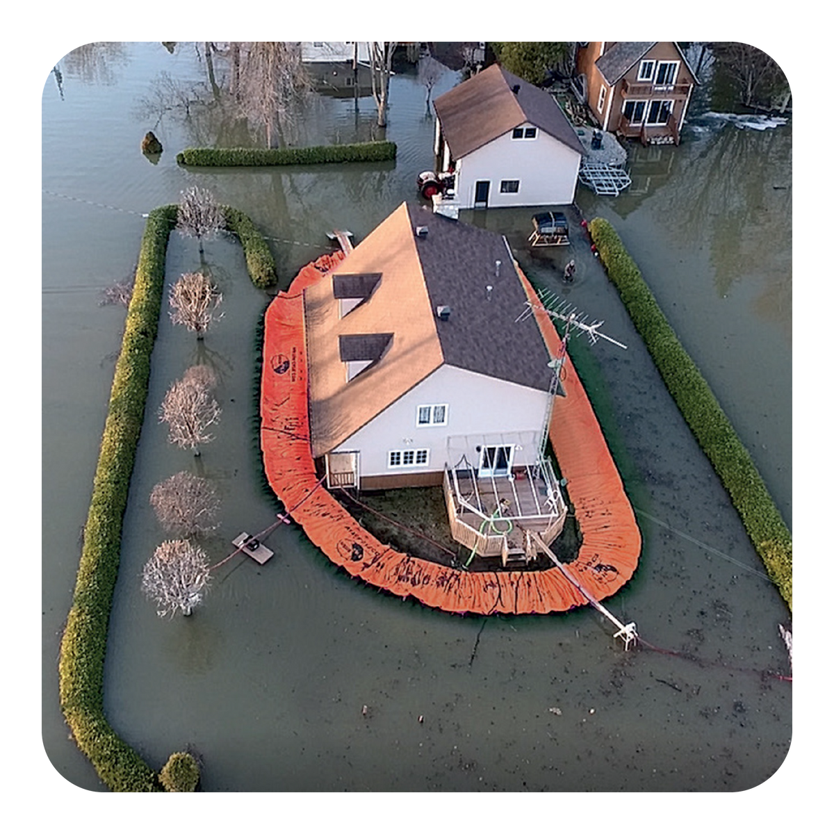 House surrounded by floodwaters with an orange water force