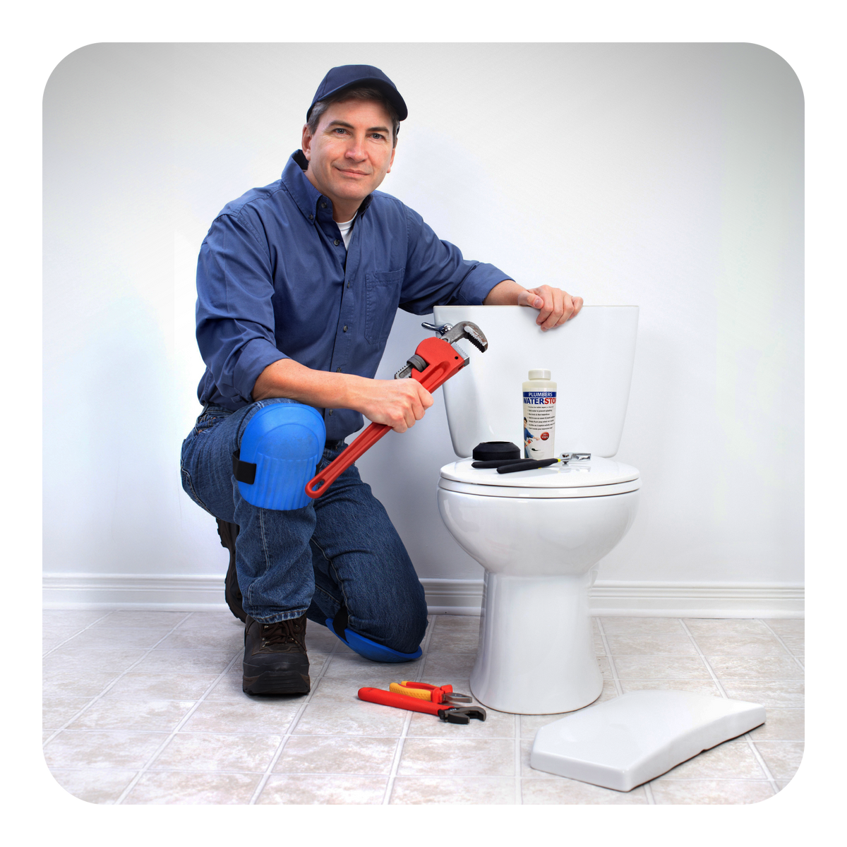 Plumber working on a toilet with tools in a bathroom setting